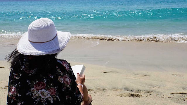 Plaža, more, žena, čitanje knjige